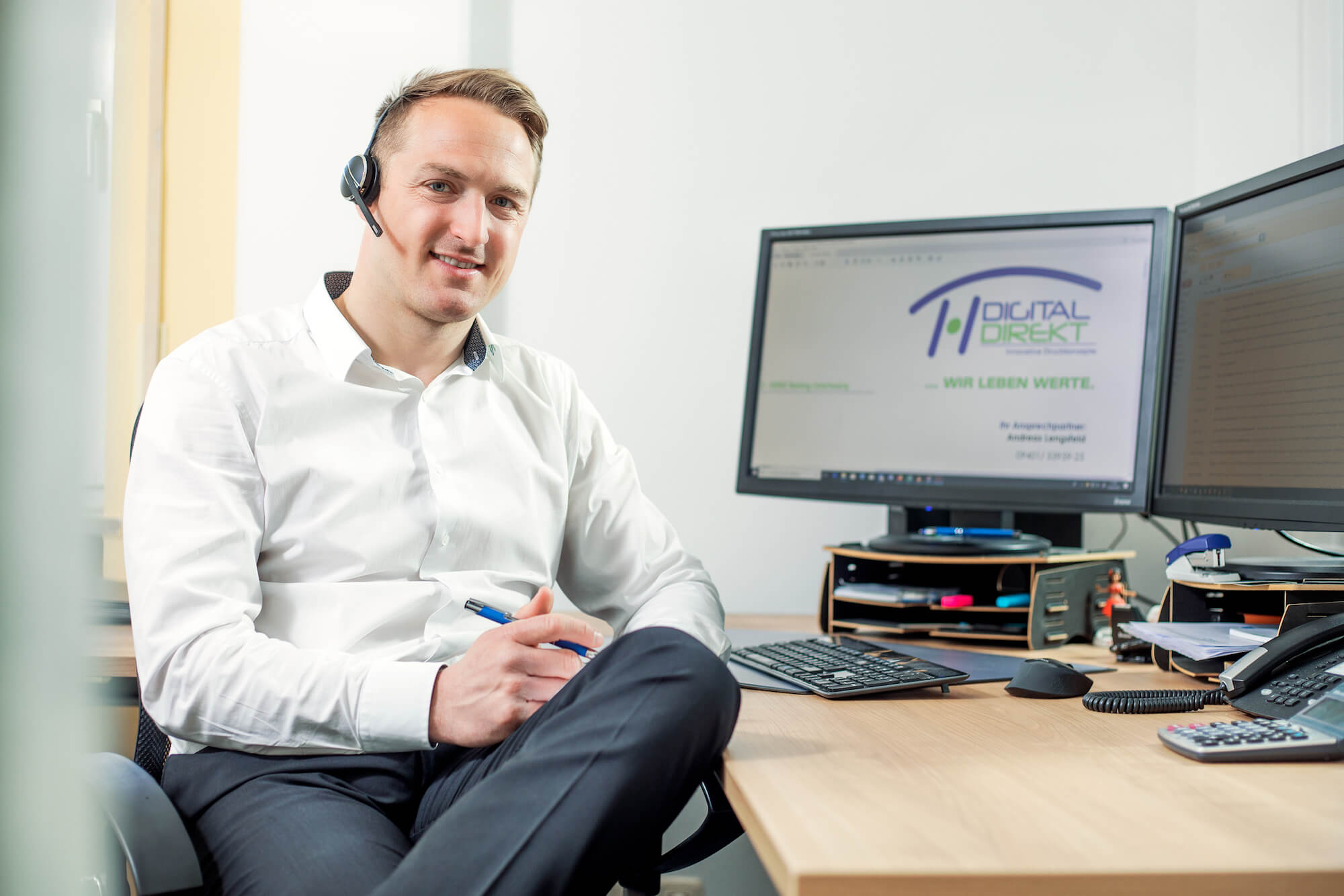 dreifoto_DREI5384.jpg Vertriebsspezialist an Schreibtisch mit Headset - Digital Direkt - Regensburg